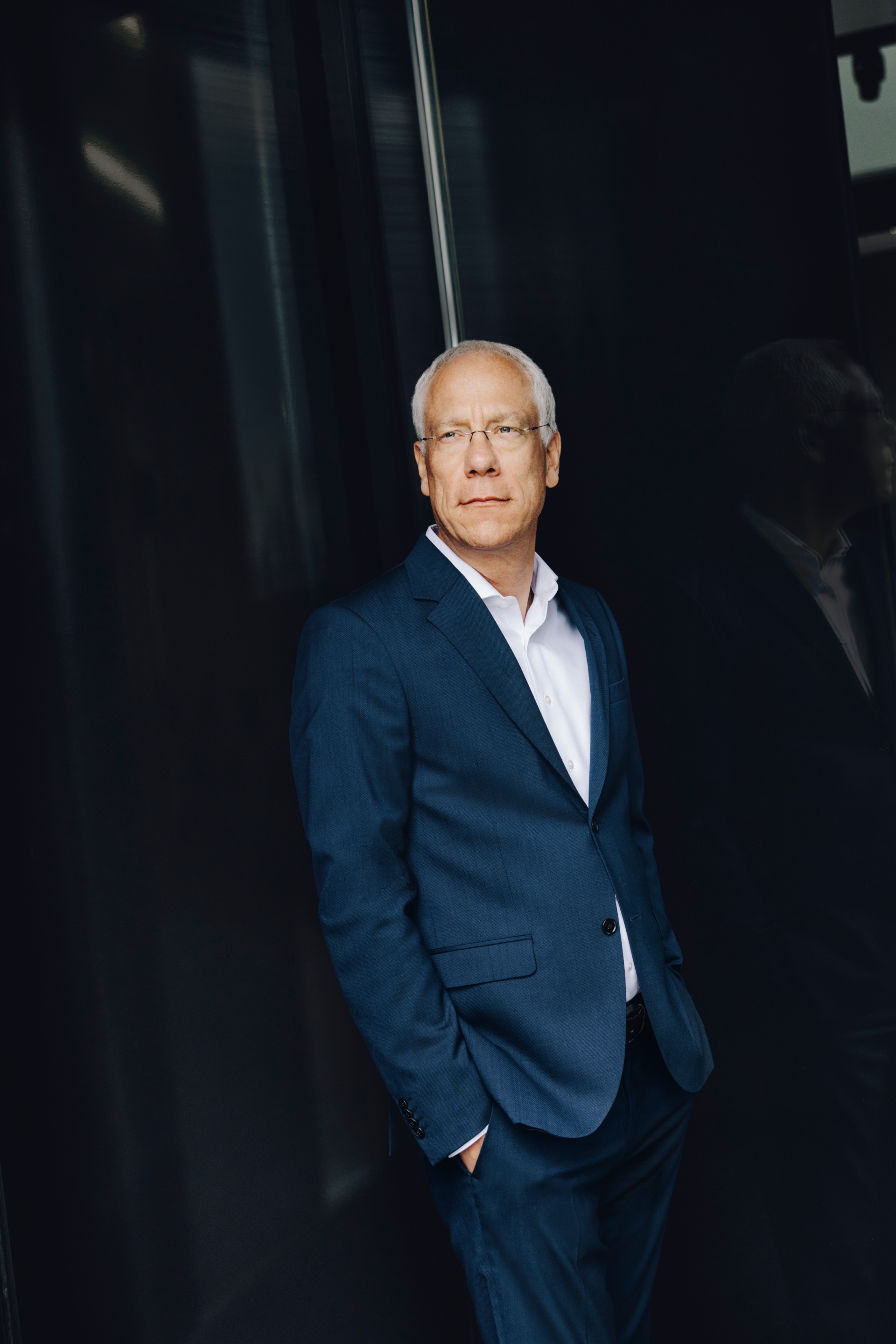 Peter Gladbach standing in front of a dark door.