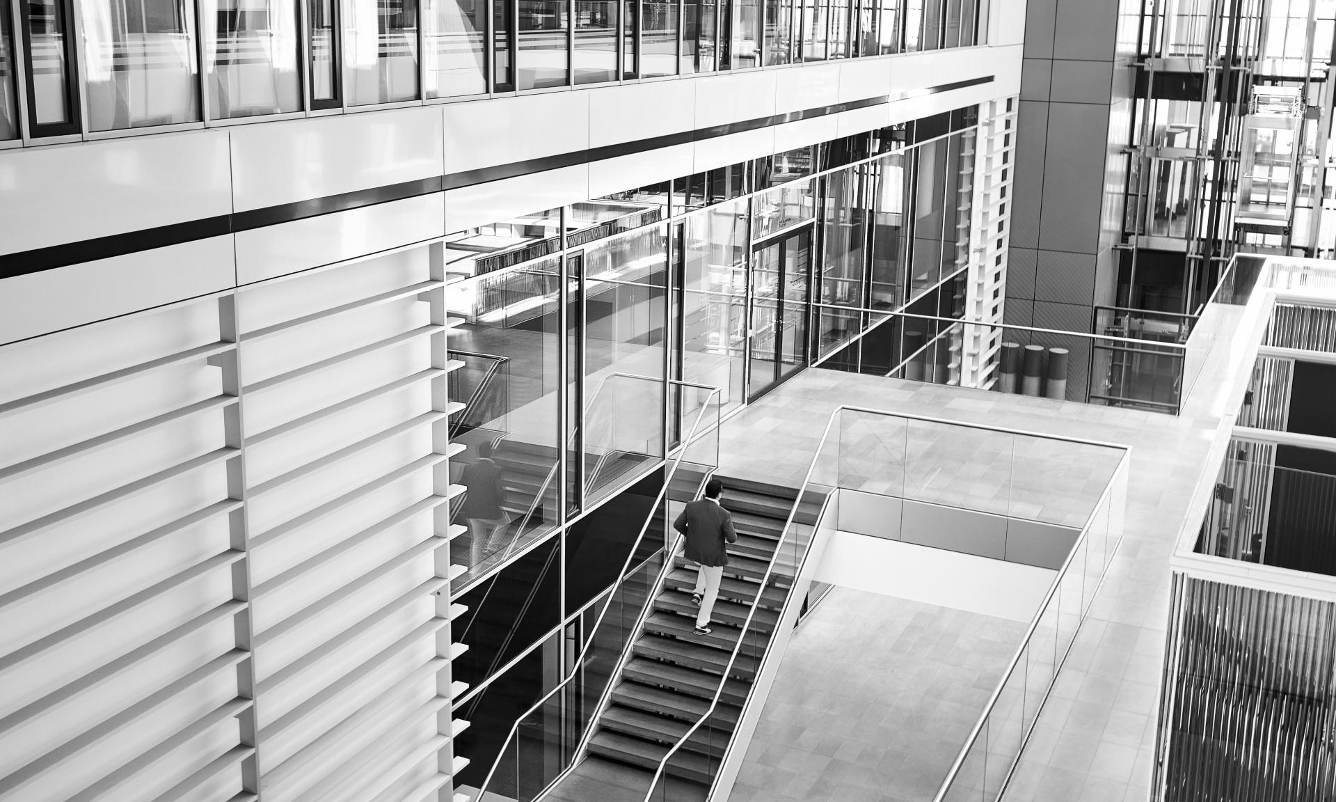 A spacious staircase in which Giorgio Delucchi is climbing up the stairs.