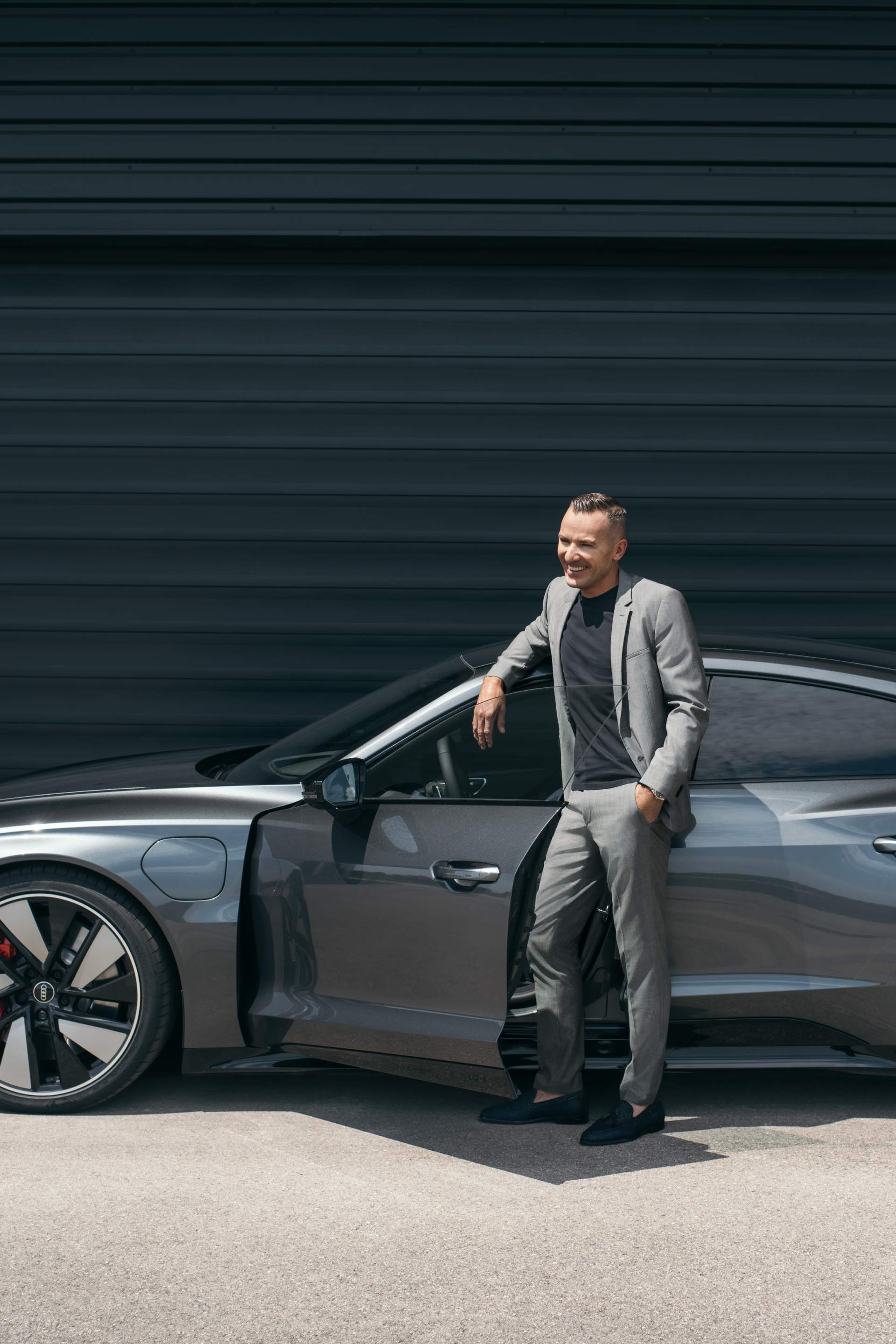 Henrik Wenders leaning against the Audi e-tron GT quattro.