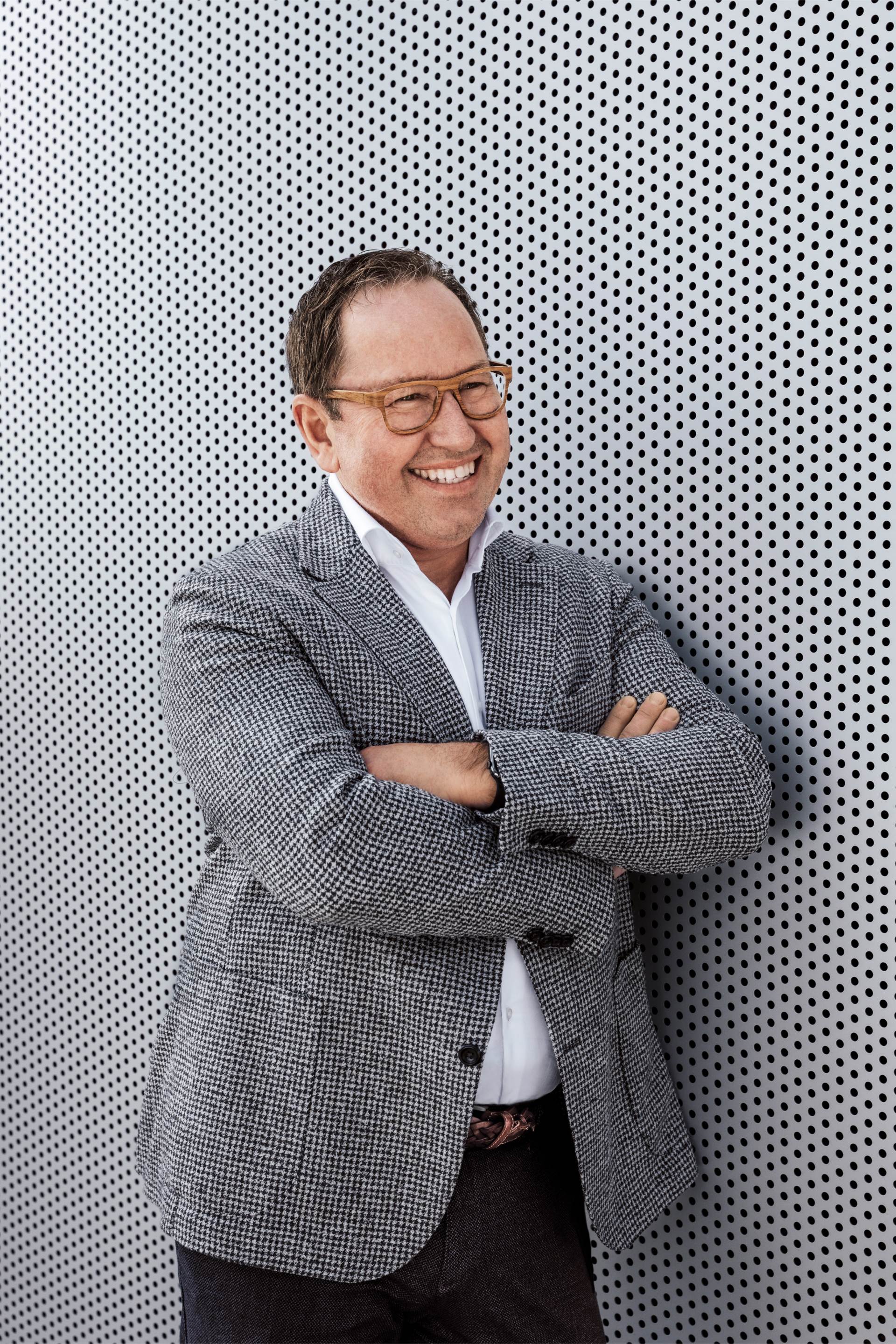 Helmuth Brants standing in front of a wall, smiling.