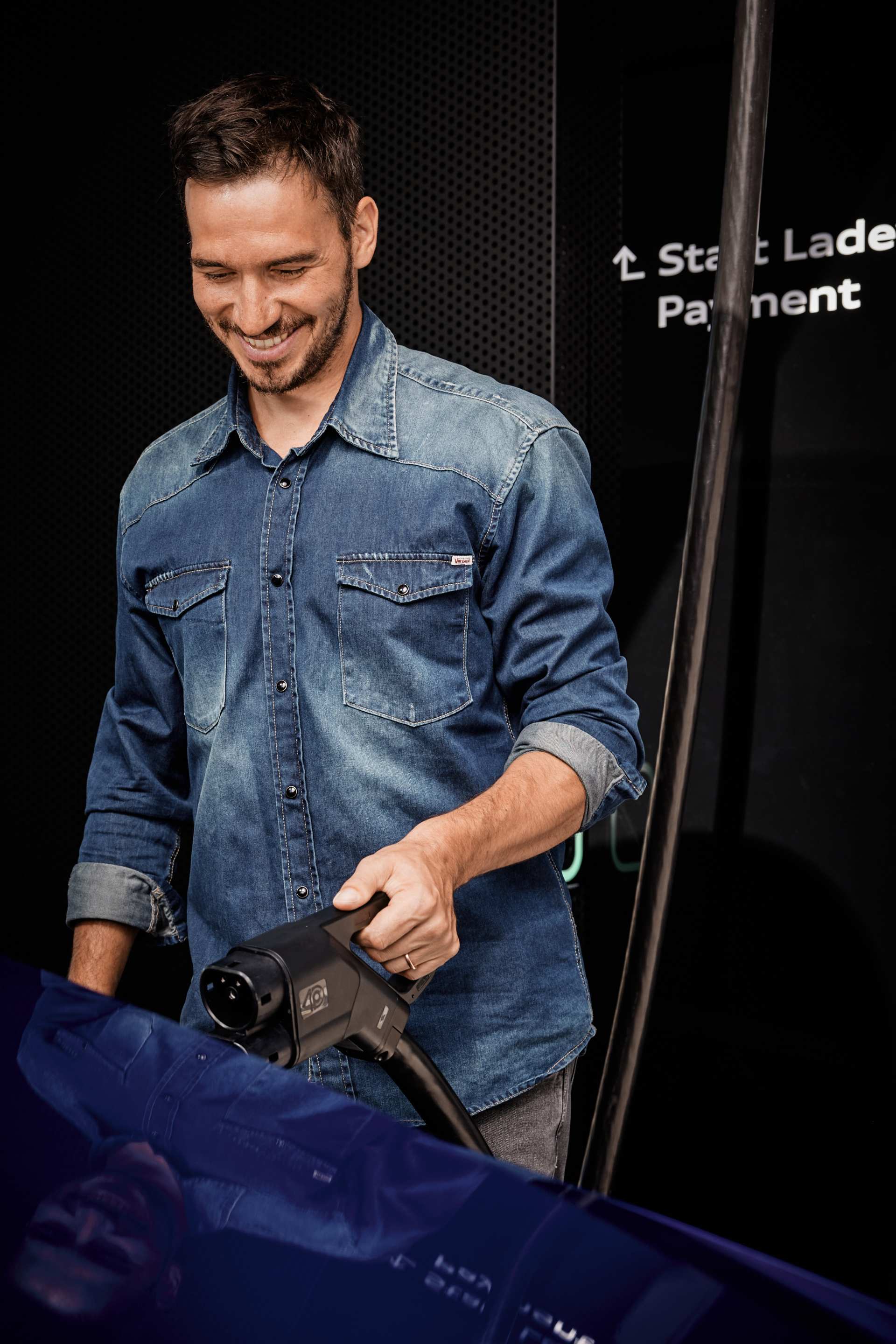 Felix Neureuther with a charging plug in his hand.