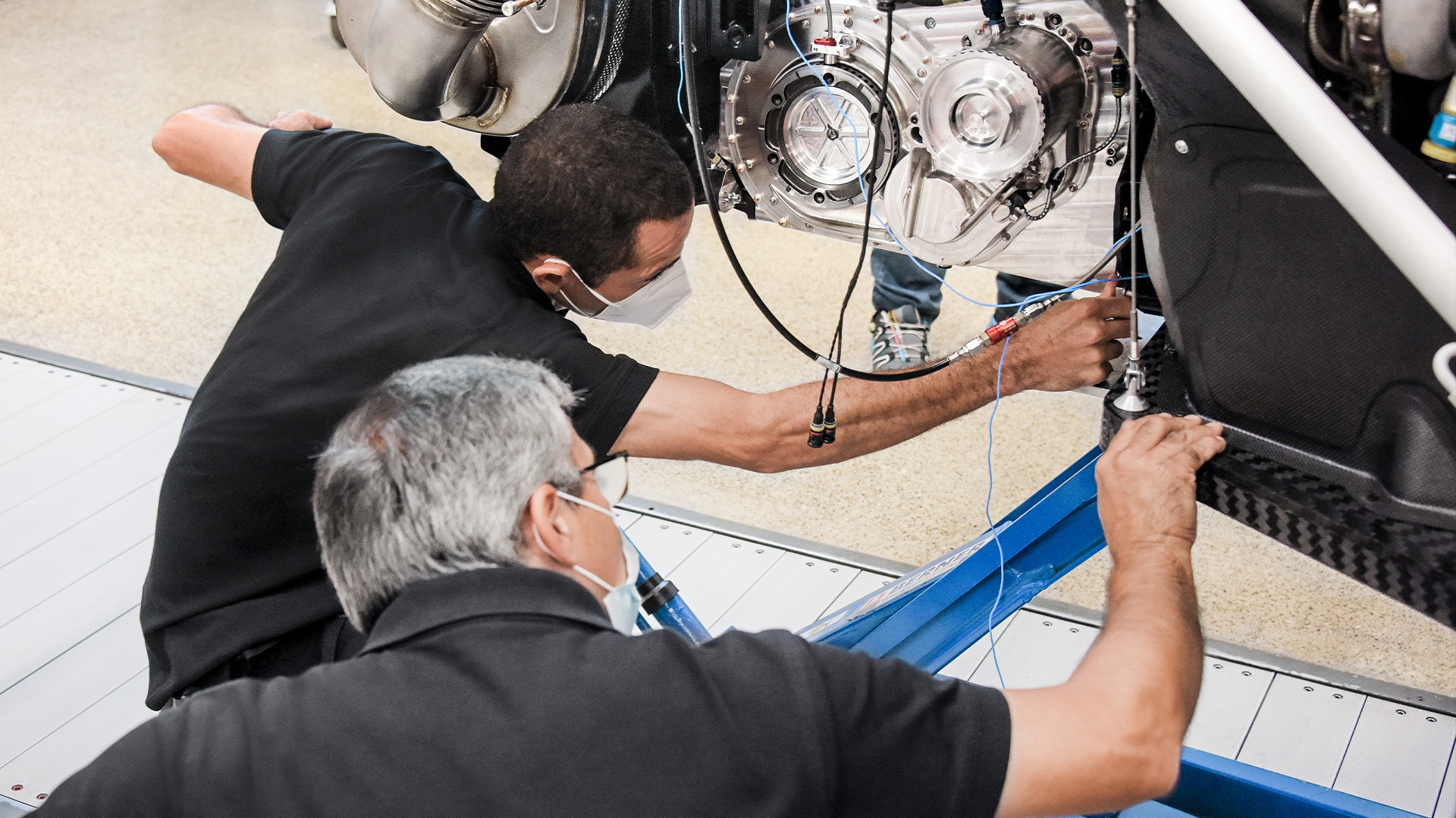 Working on the heart of the Audi RS Q e-tron{ft_rs-q-e-tron}: Two Audi Sport employees check the vehicle’s drive system, which will take it to the starting line of the Dakar Rally.