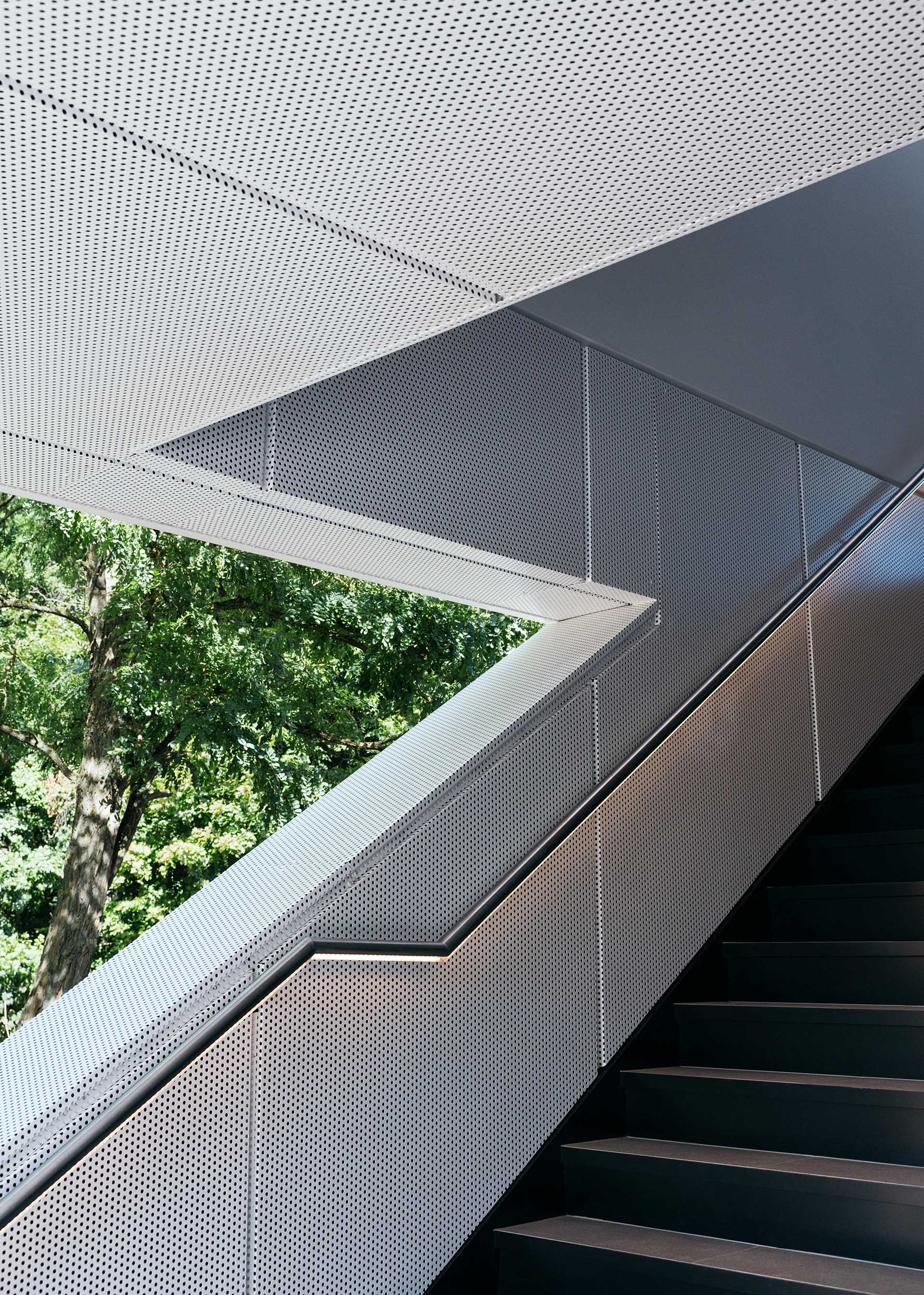 A staircase leads to the upper lounge area of the Audi charging hub.