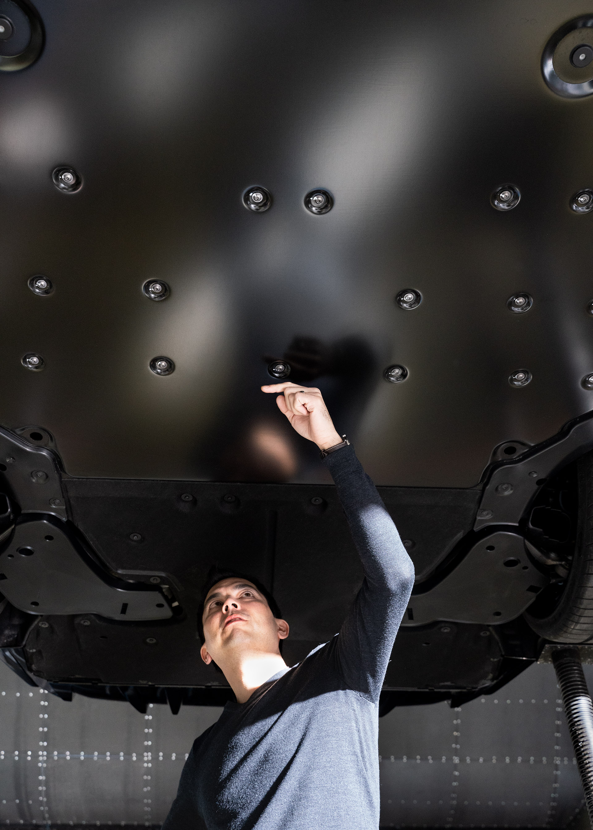 Dr. Kentaro Zens, the aerodynamicist responsible for the Audi RS e-tron GT, pointing to the underbody of the sports car.