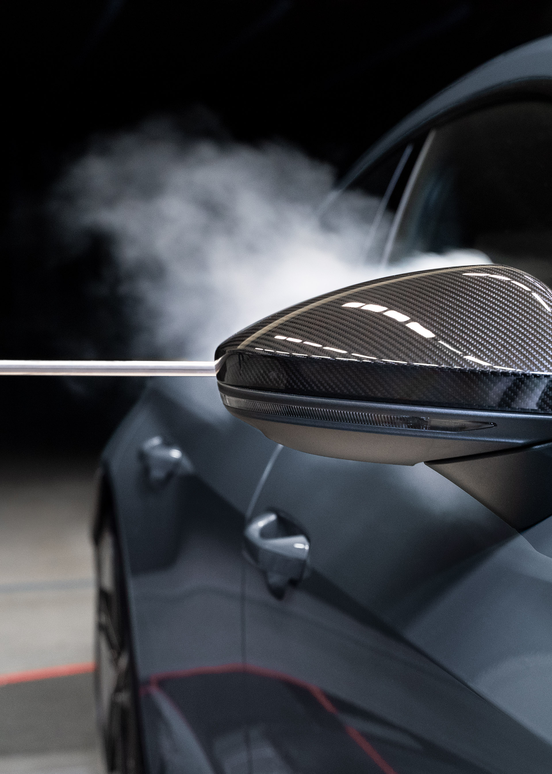 Smoke flows along the body of the Audi RS e-tron GTafter passing the exterior mirror.