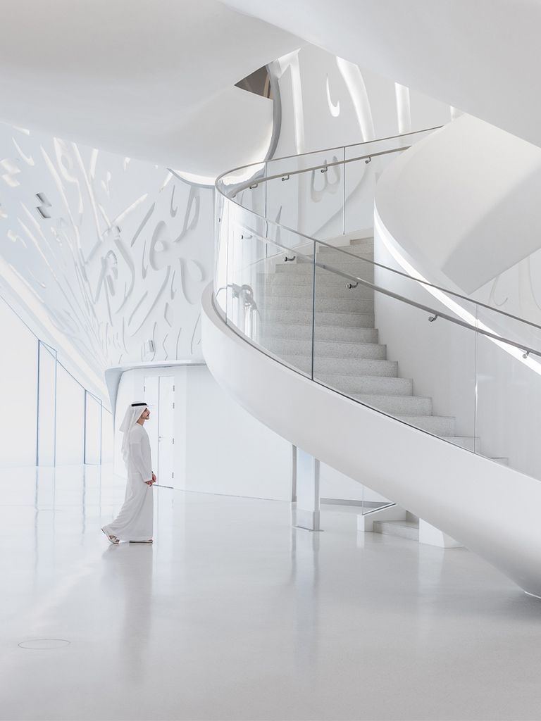 A view of the white, spiral staircase in the museum lobby.