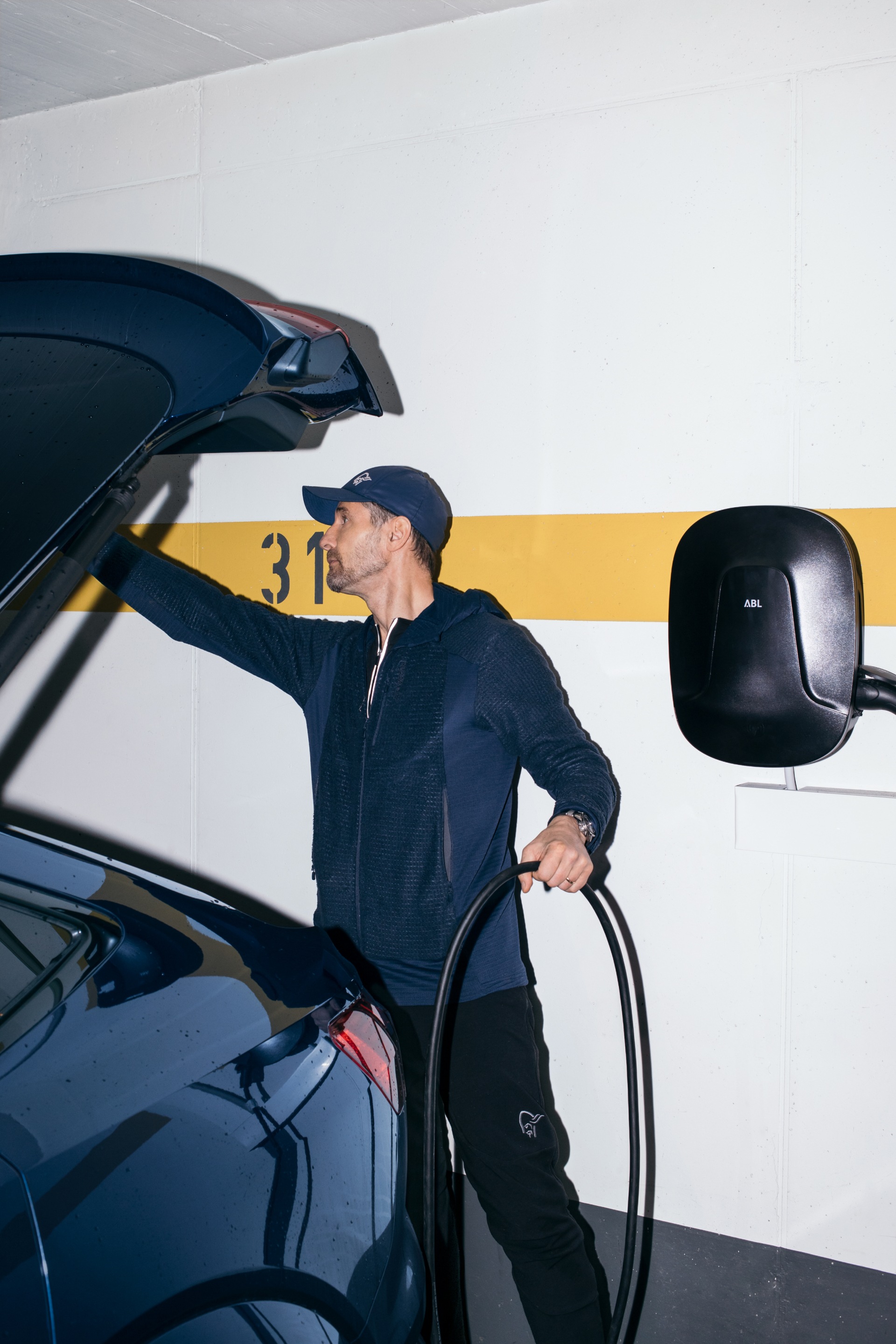 Copeland connecting his Audi e-tron to the wall box in his garage.