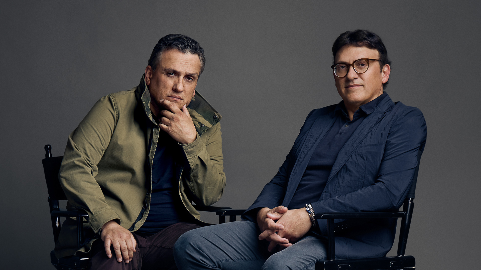 Portrait of Joe and Anthony Russo sitting in their directors’ chairs.