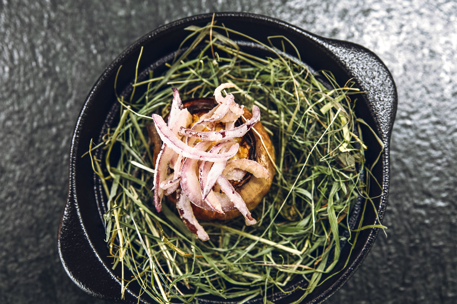 Onion on a bed of herbs.