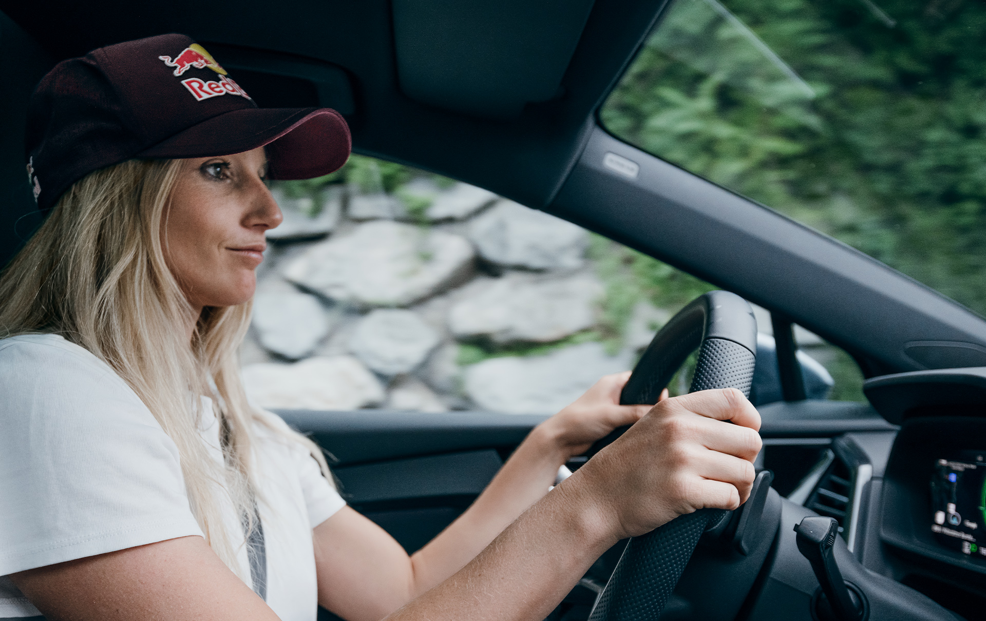 Anna Gasser sits at the steering wheel of her Audi Q4 e-tron.