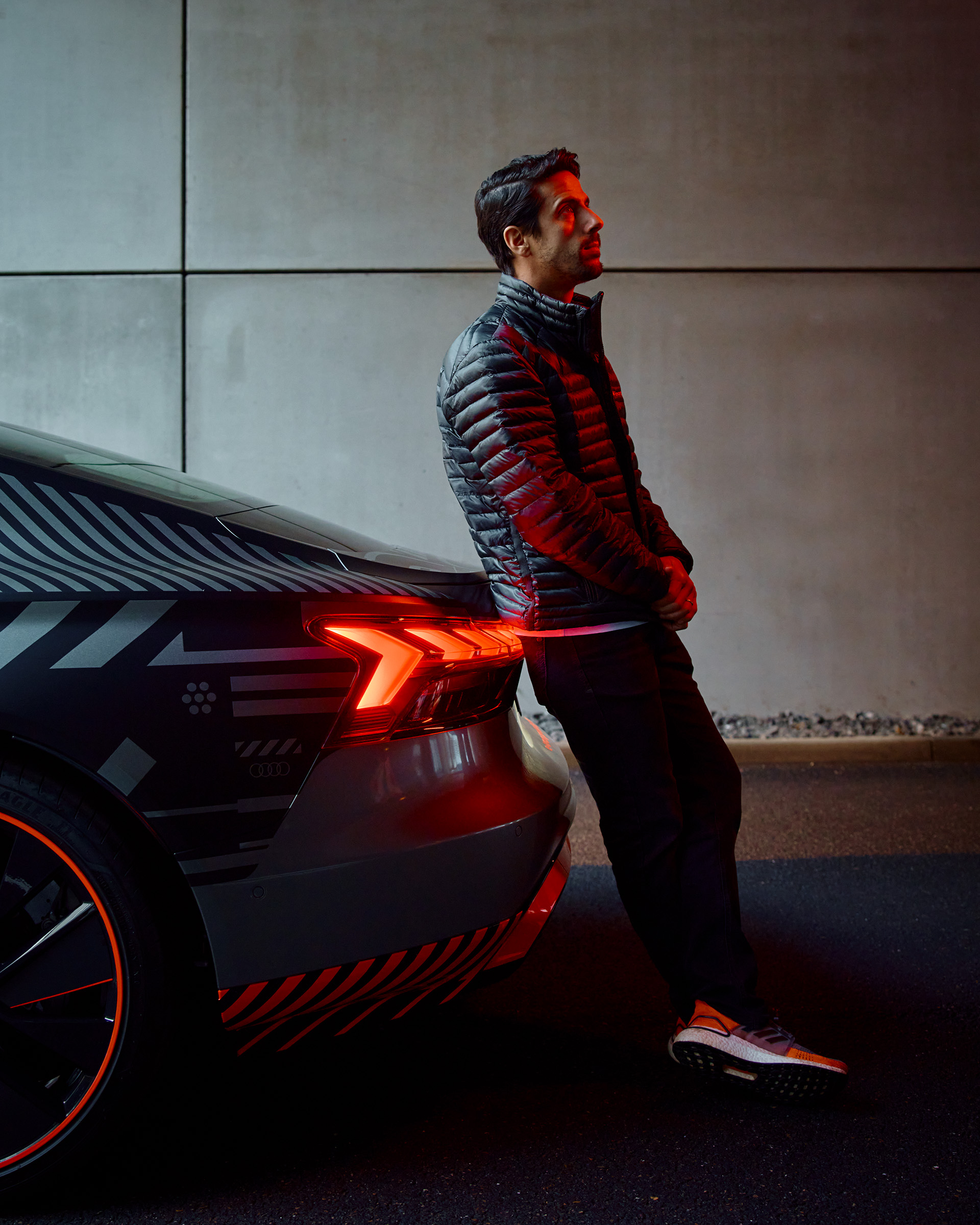 Lucas di Grassi leans against the Audi e-tron GT quattro.