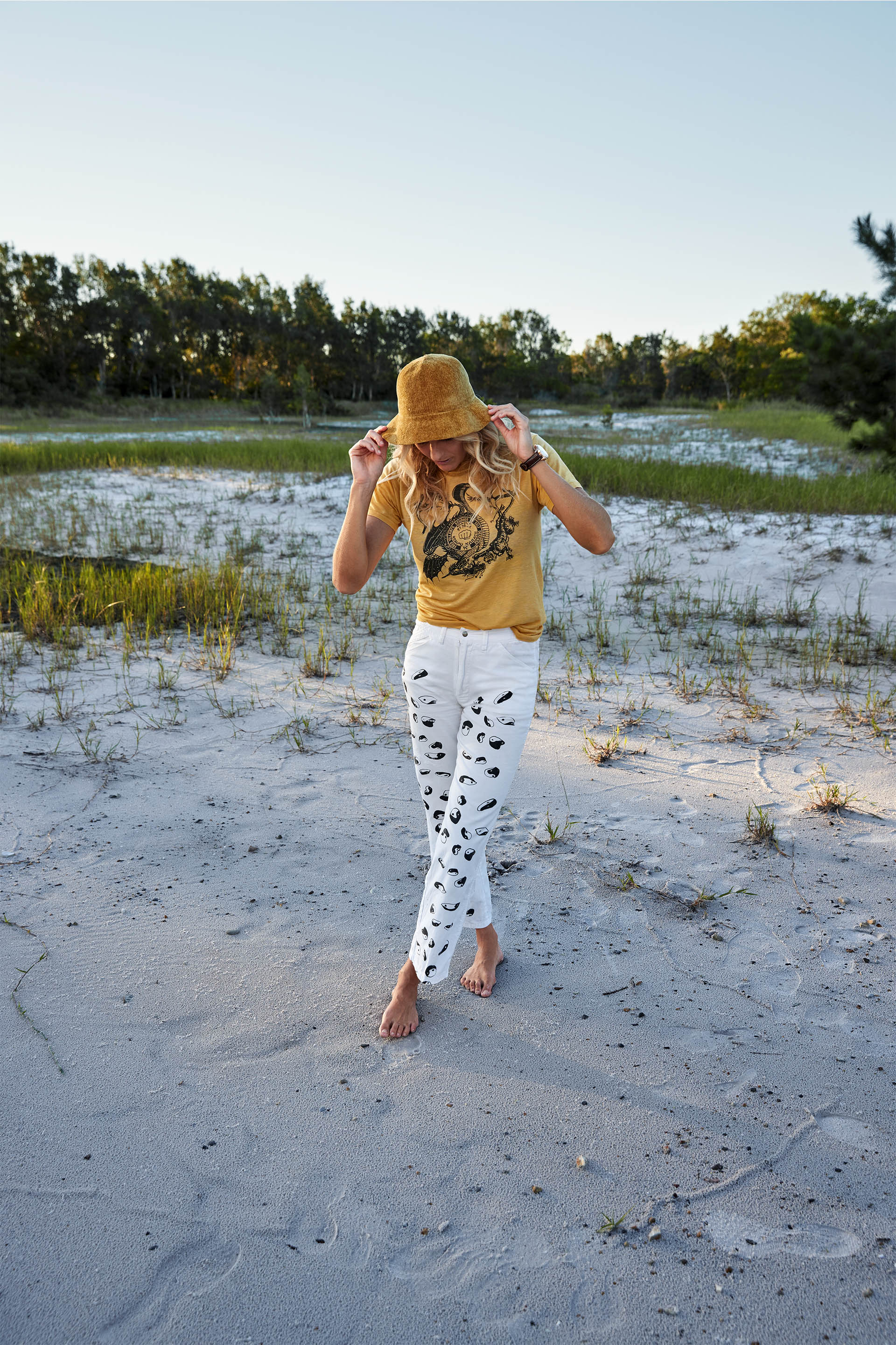 Steph Gilmore outside, in long shot, wearing a sun hat